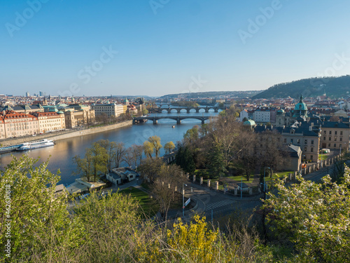 Scenic aerial view of Prague Old Town architecture and Charles Bridge over Vltava river seen from Letna hill park, spring sunny day, blue sky, Czech Republic
