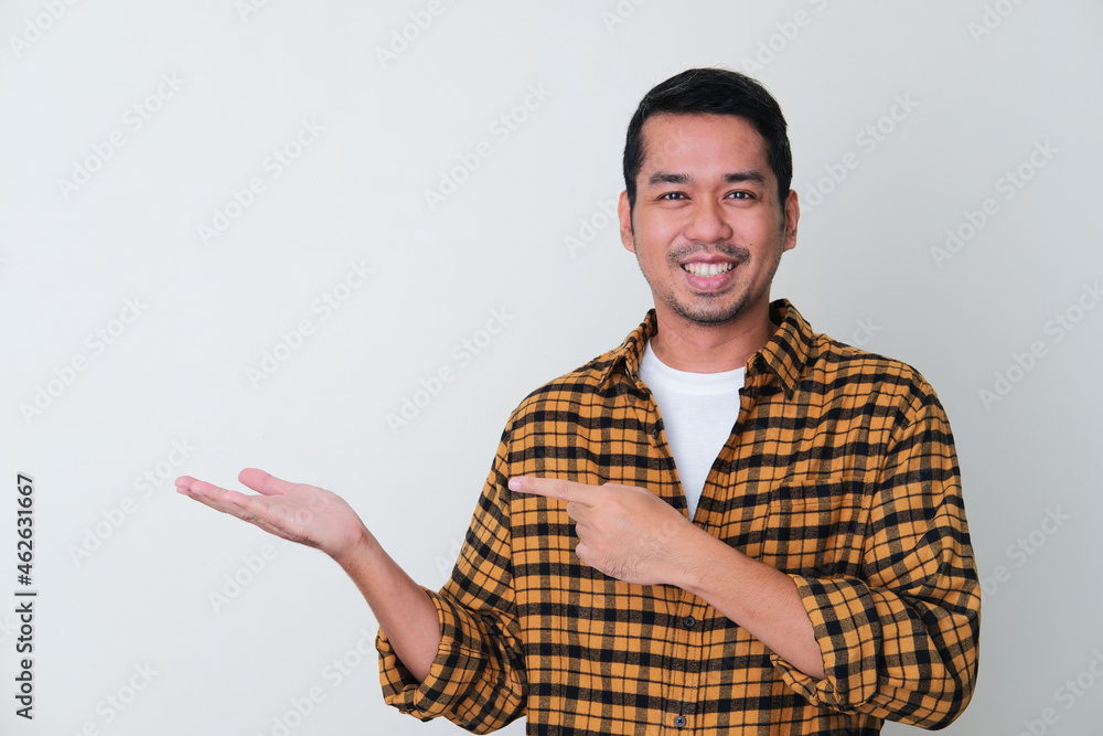 Fototapeta premium Adult Asian man pointing to his hand hand palm with smiling face