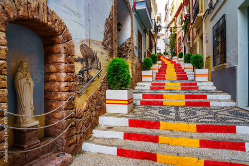 Narrow alley decorated with the flag of Spain on the steps. Calpe Alicante. photo