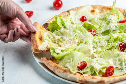 Hands taking sliced Caesar pizza with cheese and chicken, Food recipe background. Close up