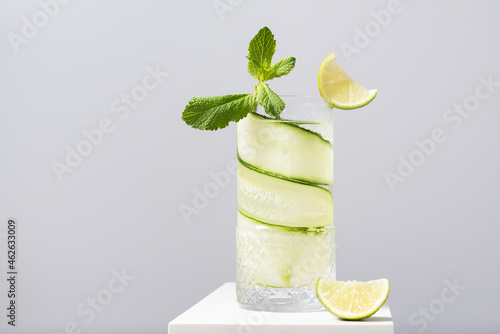 Refreshing cocktail with lime and cucumber served on white table