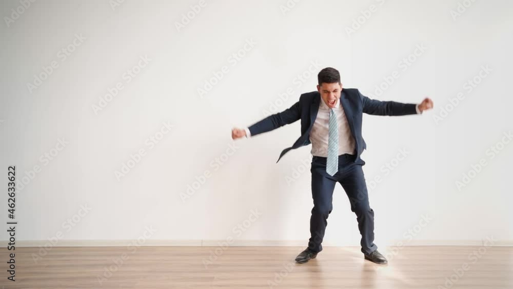 Funny business man dancing for joy and success on a white background. Happy office worker in formal clothes laughs and jumps with victory happiness. Emotions of a winner, career growth. Slow motion Funny business man dancing for joy and success on a white background. Happy office worker in formal clothes laughs and jumps with victory happiness. Emotions of a winner, career growth. Slow motion