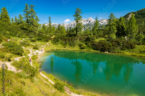 People exploring the shore of the mountain lake Märchensee, literally fairy tale lake, on the Tauplitzalm plateau, Tauplitz, Ausseer Land, Austria