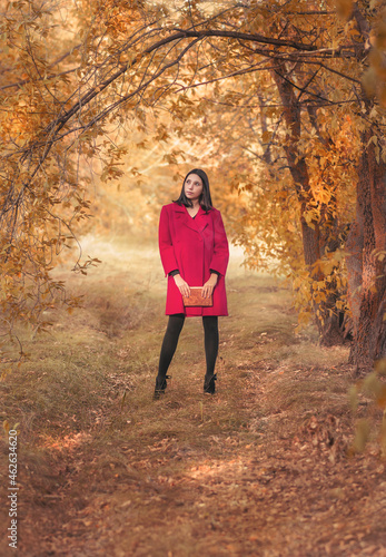 A girl with a book in the autumn forest