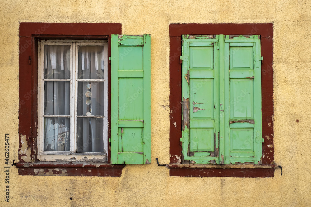 View of two windows in a house in need of renovation 