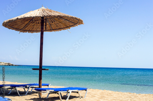 Fototapeta Naklejka Na Ścianę i Meble -  Two sun beds under sun umbrella at the beach. Zephyros beach. Greece
