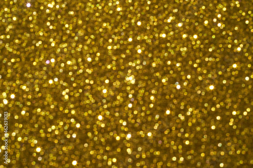 Bokeh circle with gold sparkles background. Yellow glitter backdrop. Golden texture. New year luxury snow. Copyspace. Shimmer confetti wallpaper. Dreamy shiny design detail