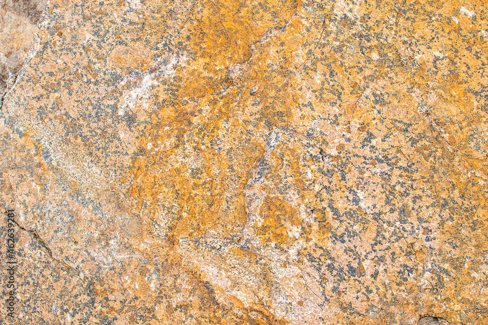 Raw rough yellow golden brown granite texture background. Natural rock stone texture background. Granite Grades. Muscovite colored minerals in granite Raw rough yellow golden brown granite texture background. Natural rock stone texture background. Granite Grades. Muscovite colored minerals in granite