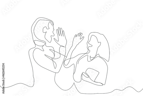 man and woman working together at work holding hands laughing. teamwork at work. employees working together.