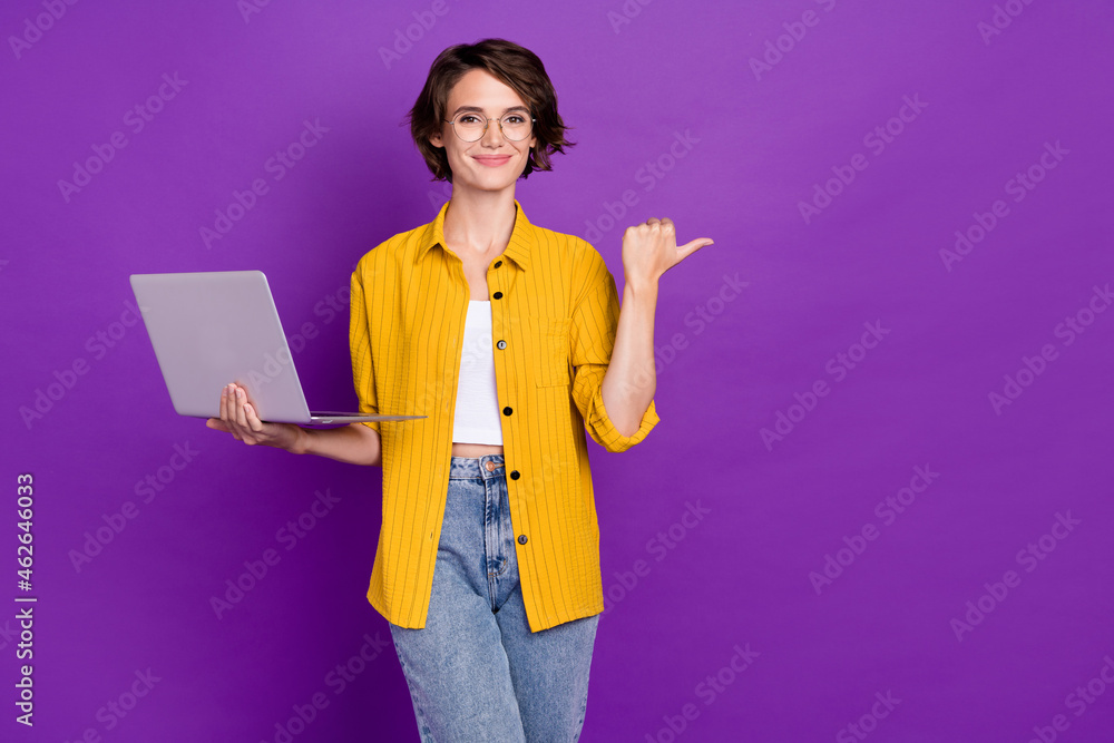 Portrait of attractive trendy cheery girl holding laptop showing copy space isolated over bright violet purple color background - obrazy, fototapety, plakaty 