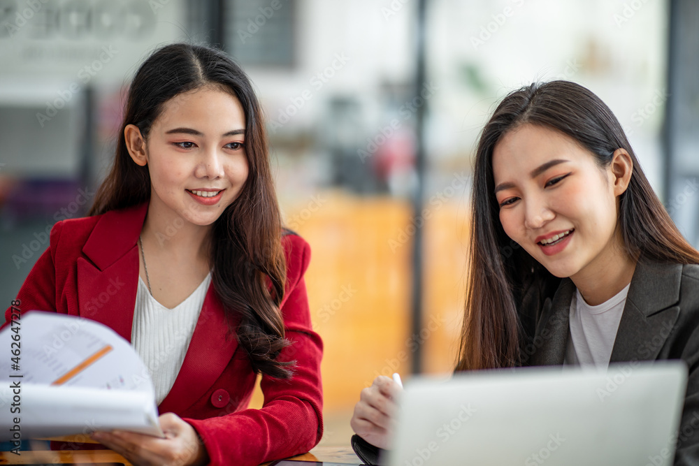 Two business Asian young women working together with laptop computer in the modern office. Two business Asian young women working together with laptop computer in the modern office.