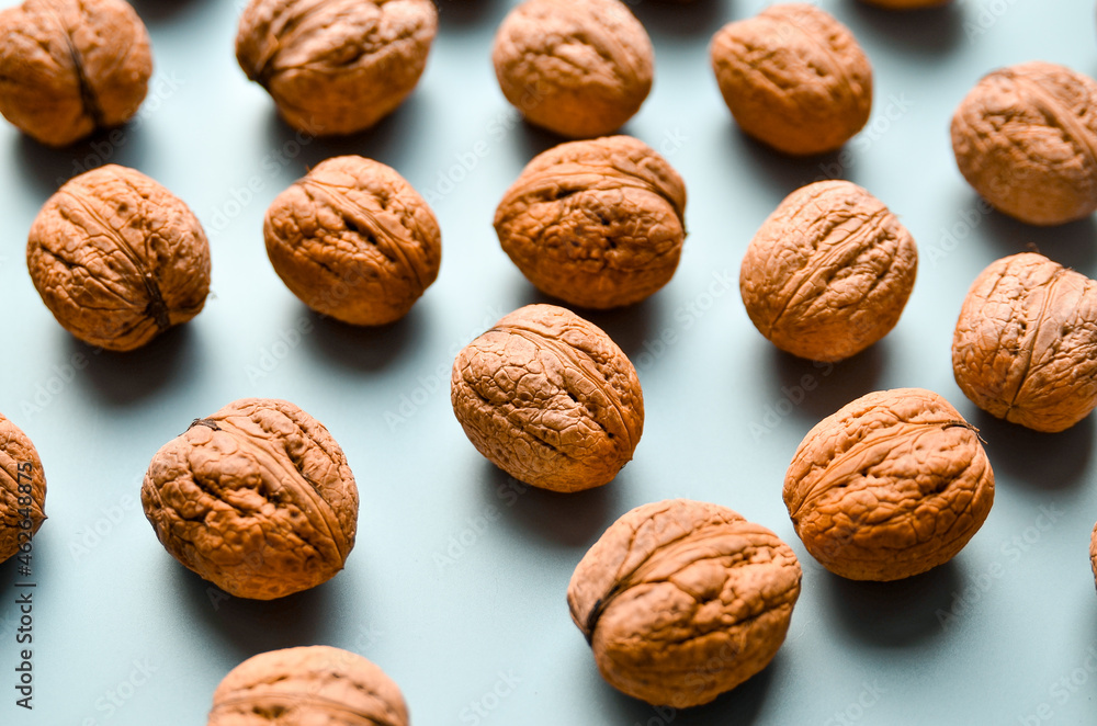 Walnuts on grey background as pattern, flat lay with copy space. Walnuts on grey background as pattern, flat lay with copy space.