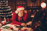 Profile side photo of aged santa claus amazed shocked omg news read browse internet computer noel atmosphere indoors