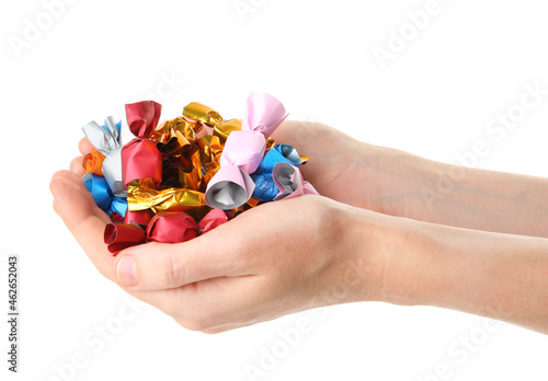 Woman holding heap of candies in colorful wrappers isolated on white, closeup