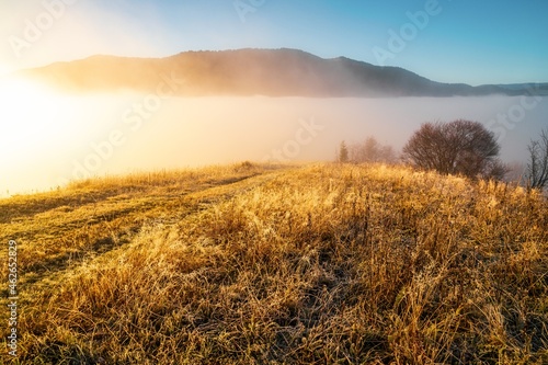 Frozen road against the backdrop of a beautiful sky and fluffy fog