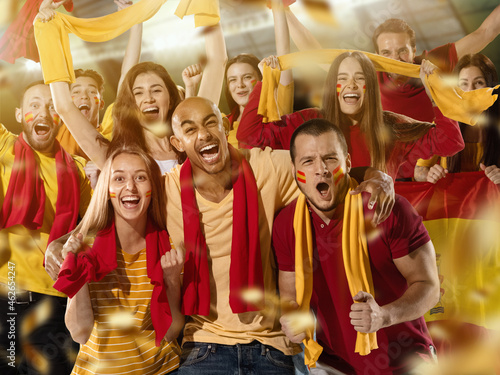 Spanish football, soccer fans cheering their team with yellow red scarfs at stadium. Concept of sport, emotions, team event, competition. photo