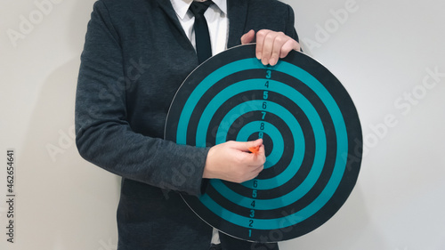 Close up shot of the dart arrow hit on bulleyes of dartboard to represent that the business reached the target of company with dark tone picture style. Target and goal as concept. 