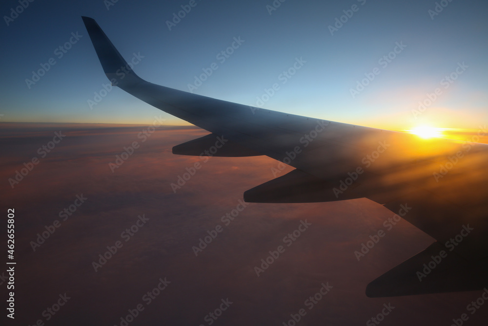 Flying and traveling, view from airplane window on the wing on sunset time. Flight in sky. Flying and traveling, view from airplane window on the wing on sunset time. Flight in sky.