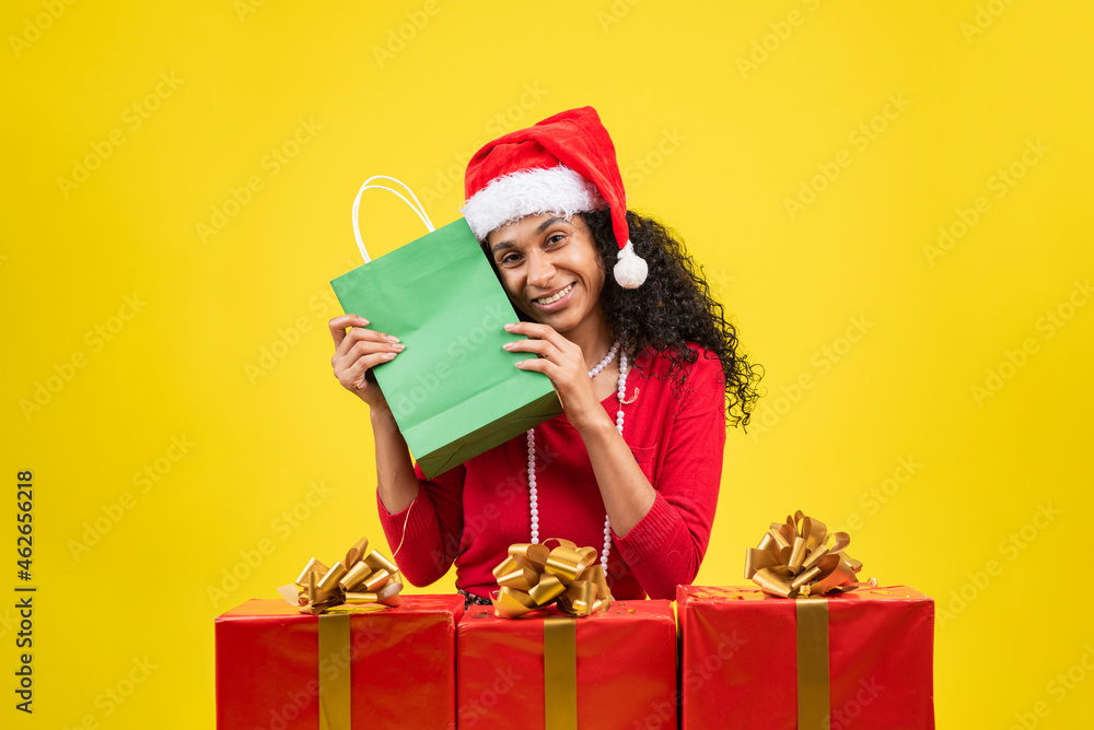 mujer afroamericana en fondo amarillo con bolsas de regalo en navidad mujer afroamericana en fondo amarillo con bolsas de regalo en navidad
