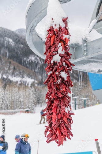 Dried chili peppers, called ristras, hanging  from a chair lift at the ski resot in Taos, New Mexico. photo