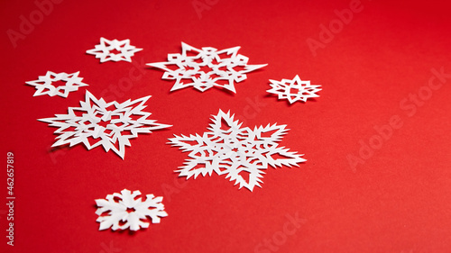 Christmas decoration with white paper snowflakes on red © mikeosphoto
