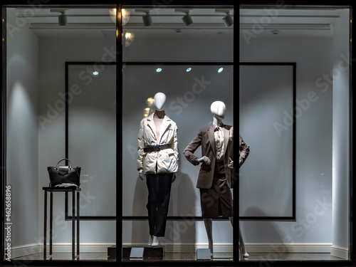 Shop windows and mannequins. Fashion Store exterior. City Night Boutique. Front View from street outdoor. LED light. City facade background