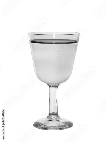 Shot glass on a thin leg filled with transparent alcohol. Isolated on a white background