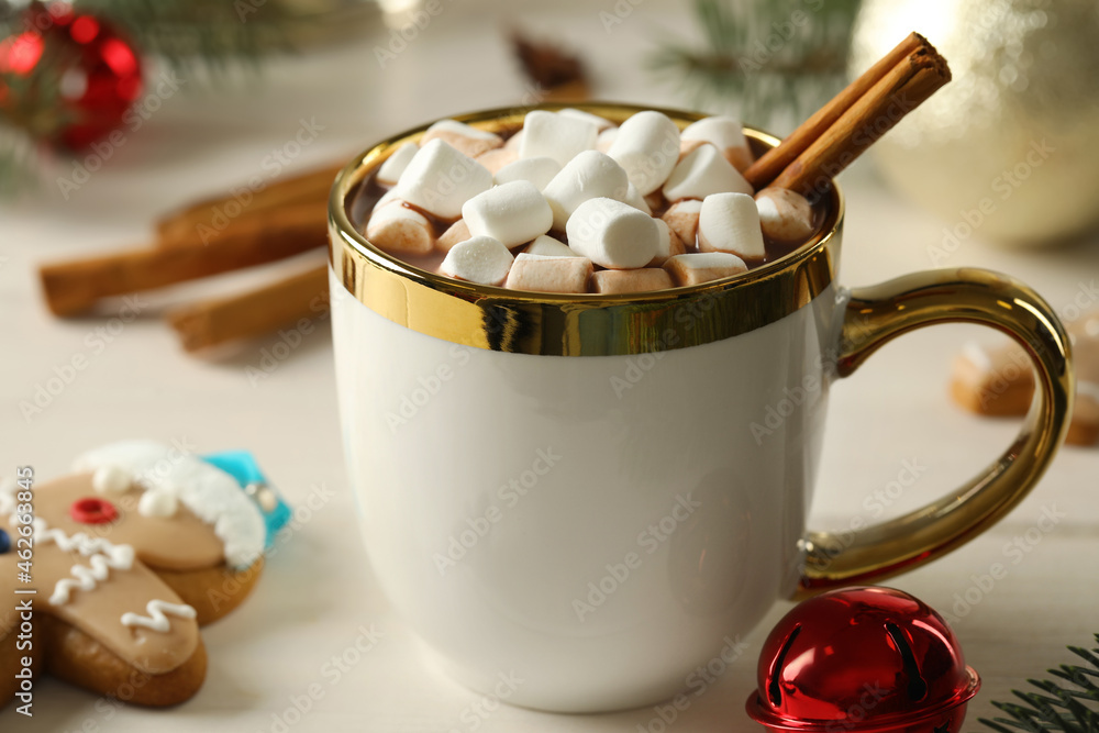 Delicious hot chocolate with marshmallows and cinnamon on white wooden table, closeup Delicious hot chocolate with marshmallows and cinnamon on white wooden table, closeup