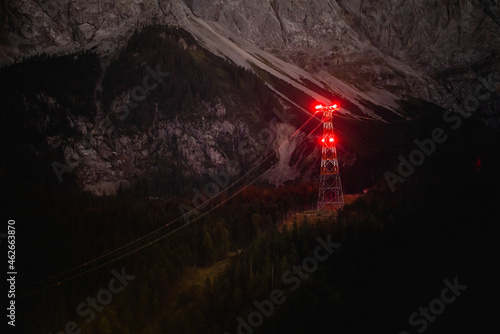 Power pole in dark forest at night in the alps