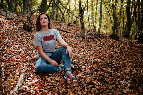 traveler hipster woman standing alone in autumn woods .