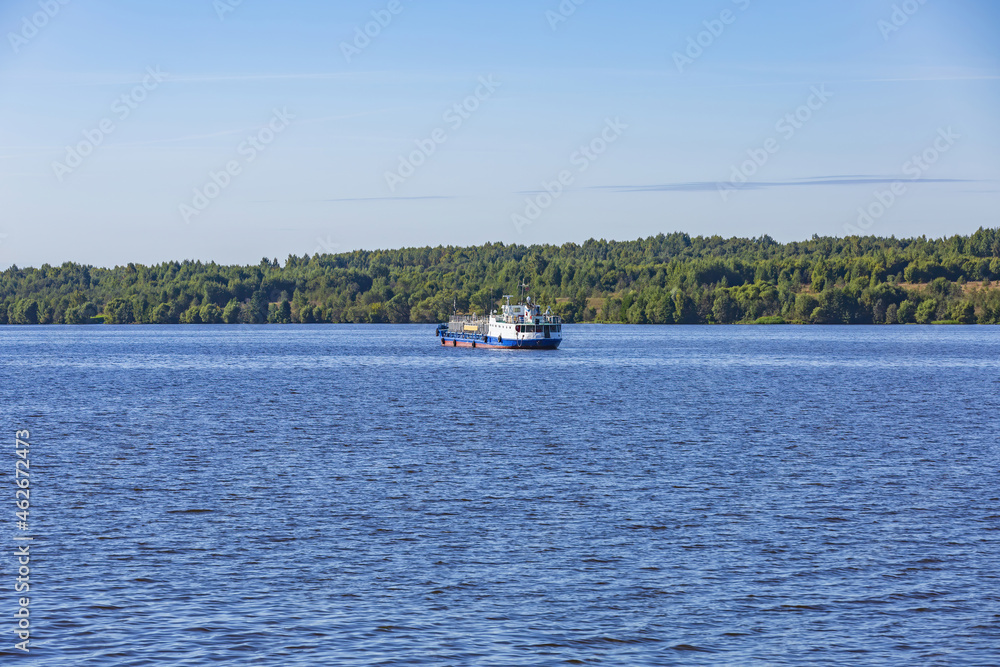 Obraz premium An old oil tanker sails along the Volga river near the forest shore. Yaroslavl Region, Russia