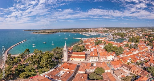 Drone panorama over the roofs of the Croatian coastal town of Novigrad with harbor and church during daytime