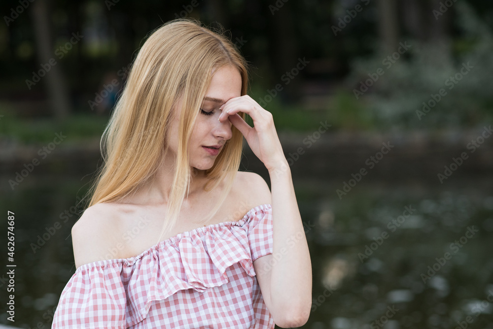 Portrait of a young and attractive blonde girl who has a headache Portrait of a young and attractive blonde girl who has a headache