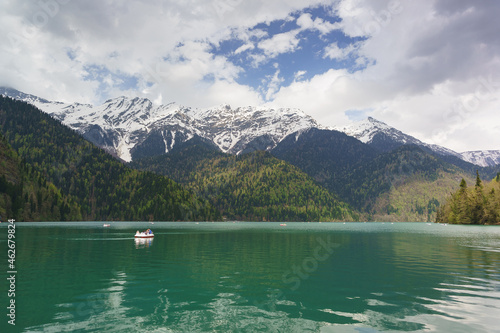 Pleasure boats on mountain lake Ritsa of glacial-tectonic origin in the Western Caucasus in Abkhazia