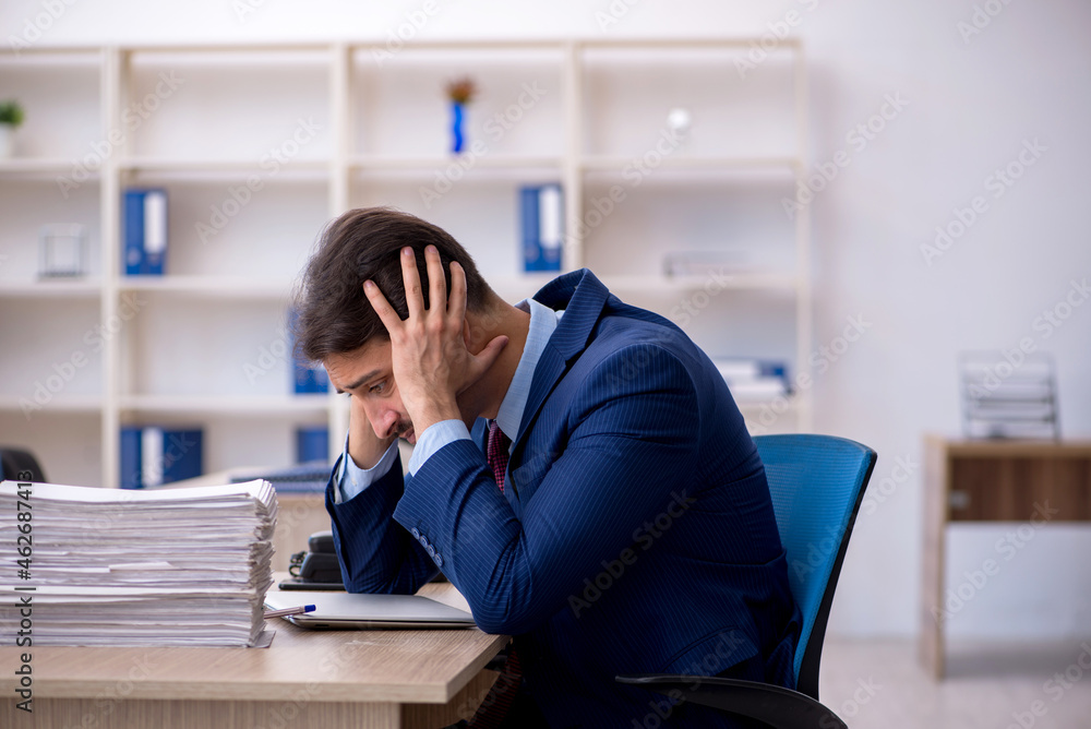 Young businessman employee and too much work in the office Young businessman employee and too much work in the office