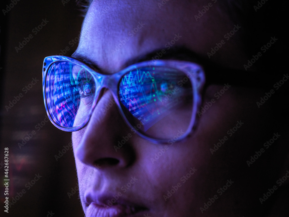 Female analyst viewing financial market data on a screen Female analyst viewing financial market data on a screen