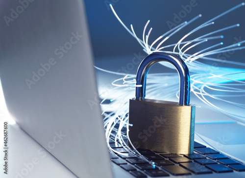 Padlock protecting laptop from computer virus represented by optical fibers