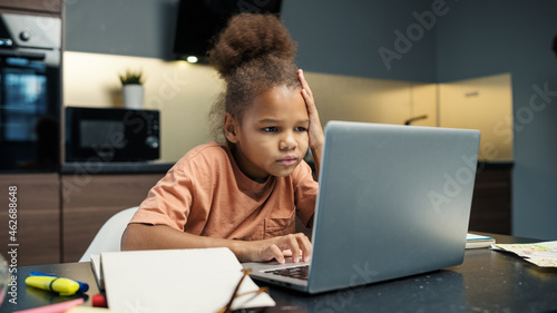 Fotografia Biracial little girl doing homework at home