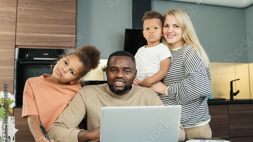 Bild auf Leinwand Portrait of beautiful loving diverse family of four looking at camera and smiling indoors
