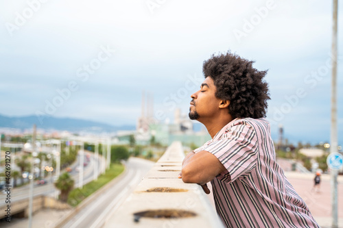 Young hipster on viewpoint, city in the background photo