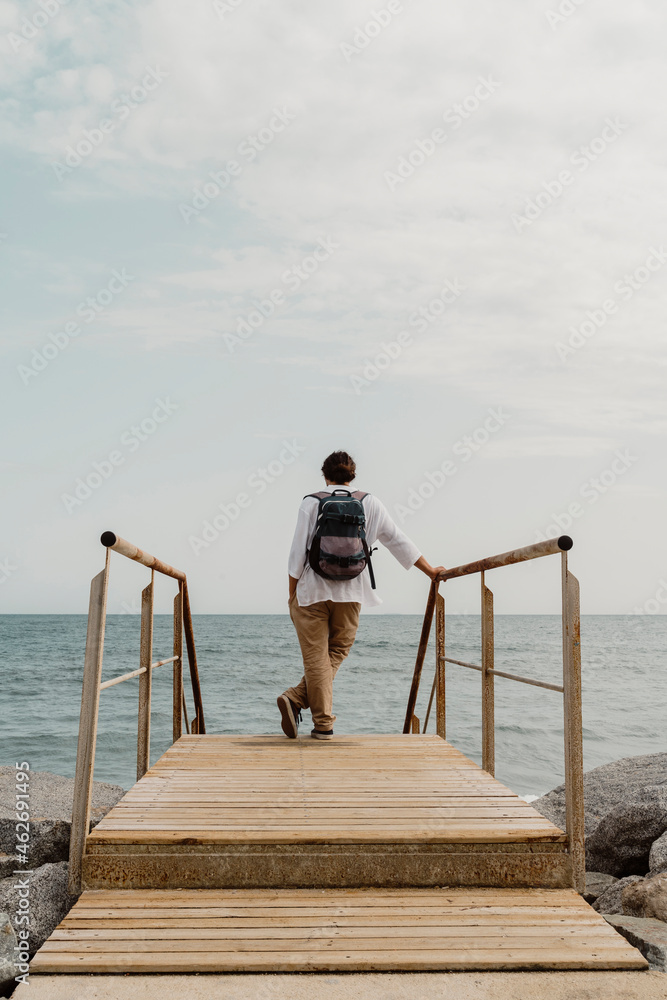 Rear view of traveller standing on wooden boardwalk Rear view of traveller standing on wooden boardwalk