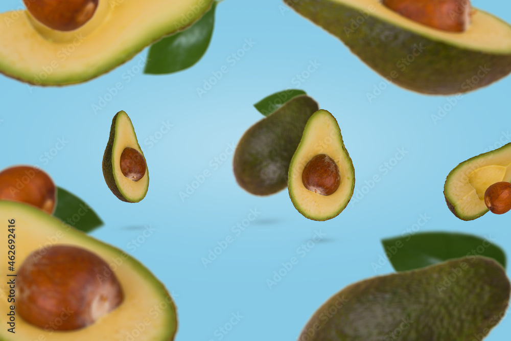 Creative scene with fresh ripe whole and sliced avocado flying in air isolated on blue background. Creative scene with fresh ripe whole and sliced avocado flying in air isolated on blue background.