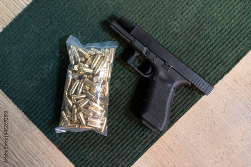 Pistol and cartridges on the table in a shooting range photo