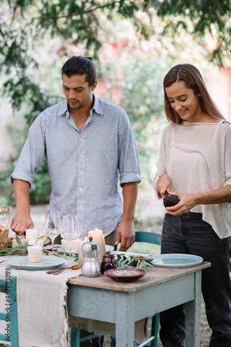 Couple preparing a romantic candlelight meal outdoors photo