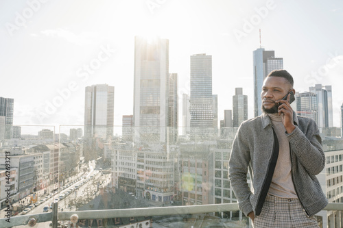 Stylish man on the phone on observation terrace with skycraper view, Frankfurt, Germany photo