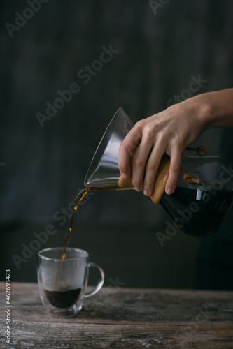Close-up of man pouring filtered coffee into a glass