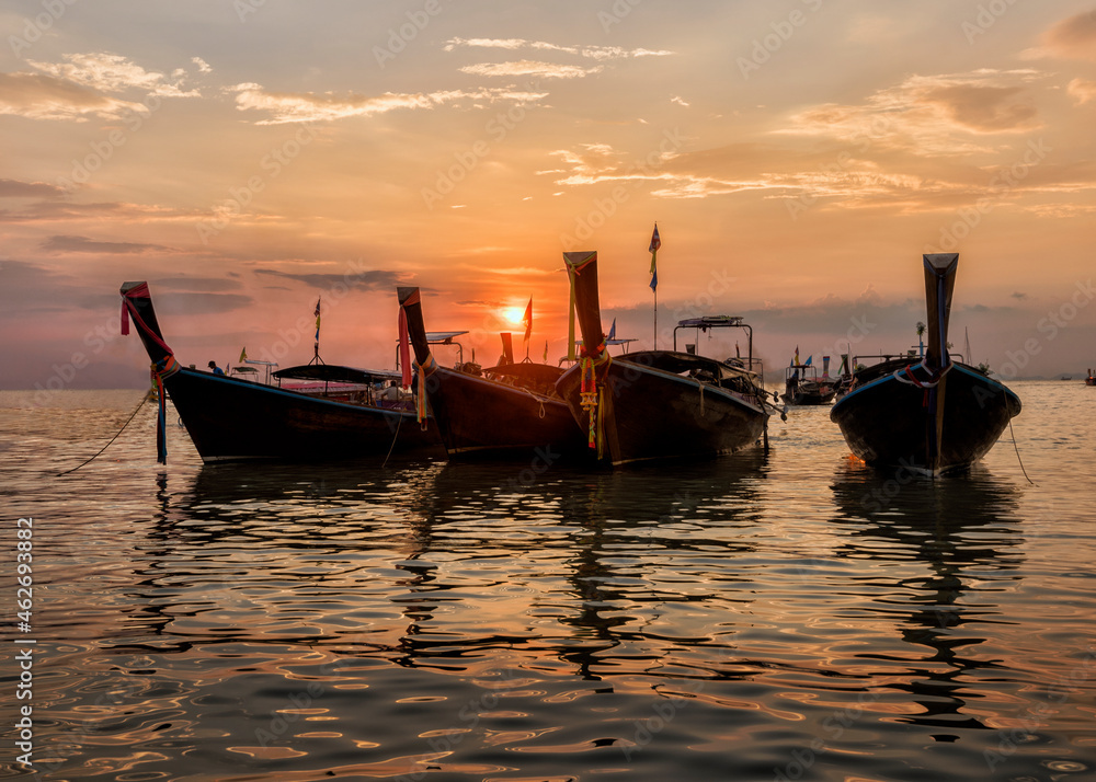 Thailand, Krabi, Railay beach, long-tail boats floating on water at sunset Thailand, Krabi, Railay beach, long-tail boats floating on water at sunset