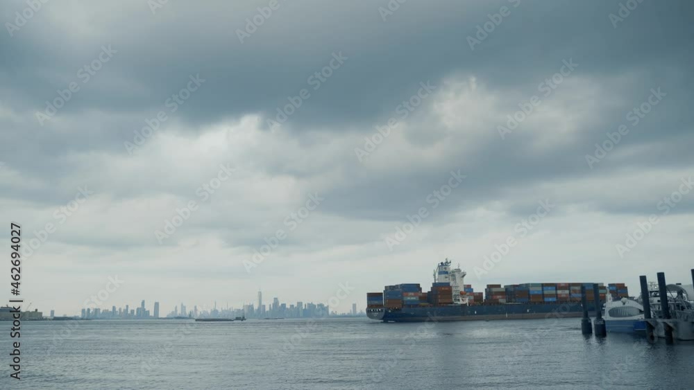 Container Ship floating along Hudson River against background with New York skyline in New York City, NY. Container Ship floating along Hudson River against background with New York skyline in New York City, NY.
