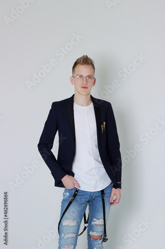 Handsome young fashion male model posing with jacket over his shoulder.