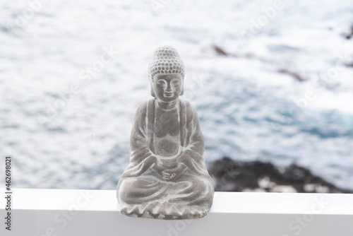 Concrete buddha figure, ocean in the background photo